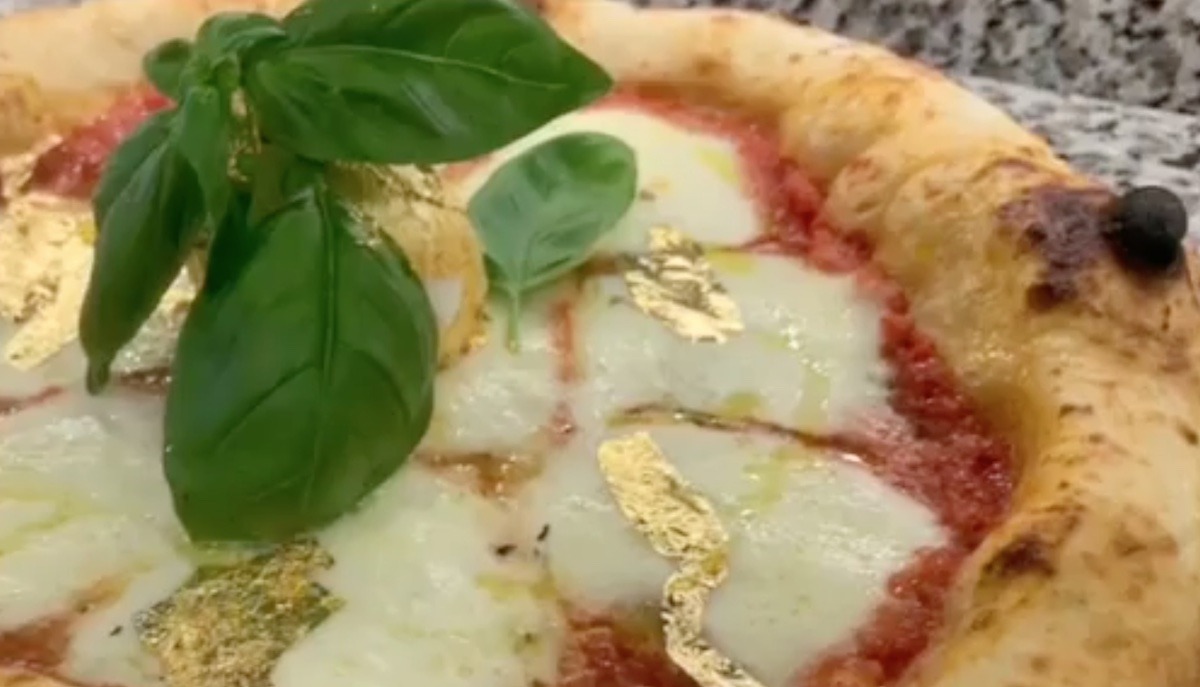 VIDEO Un rumeno ha fatto le prime pizze foglia oro in Italia / Le vende a 99 euro, e ogni ordine arriva con la canzone “We Are the Champions”