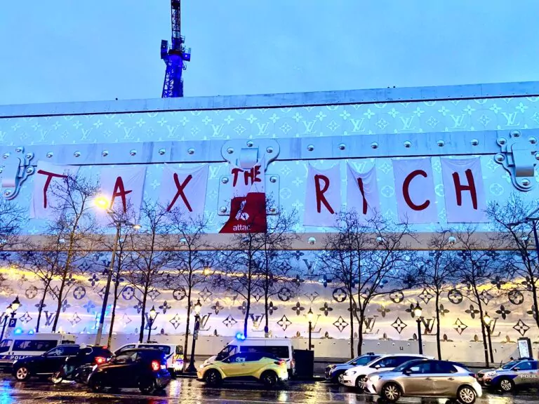 activisti, banner uriaş pe care scria "Taxaţi-i pe bogaţi